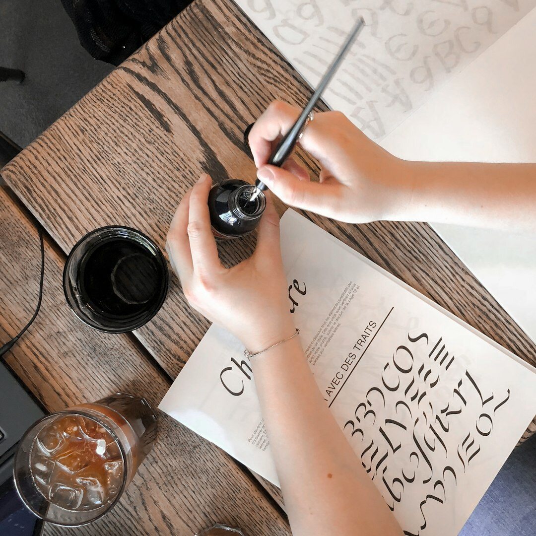 Overhead view of hands writing a manuscript with a fountain pen