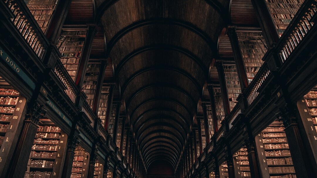 Tall old library interior with wooden shelves full of books
