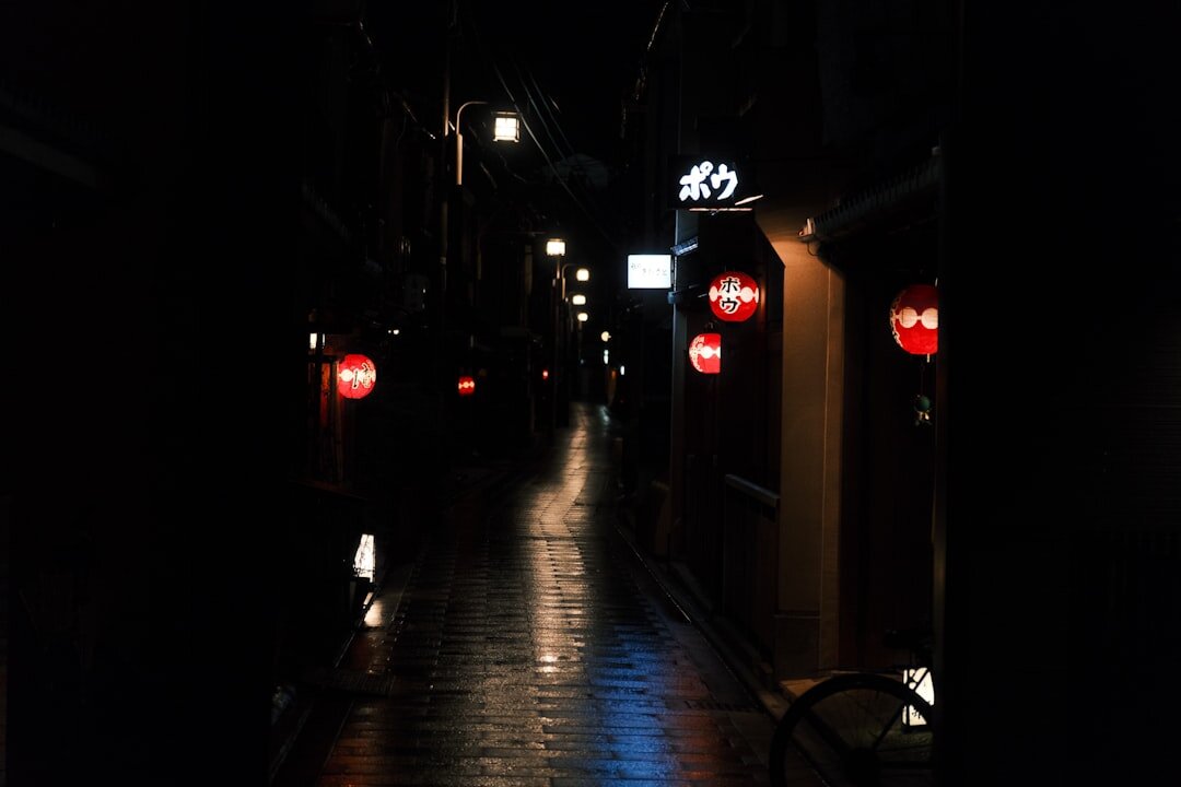 Foggy cobblestone street at night lit by a single street lantern
