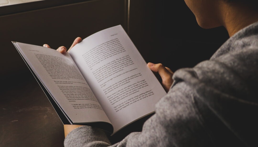 person reading thriller book at night